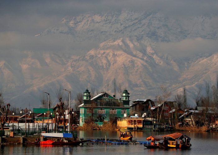 FILE PHOTO: People row their boats in the waters of Dal Lake with the backdrop of snow-covered mountains after a snowfall in Srinagar December 12, 2020. REUTERS/Danish Ismail/File Photo